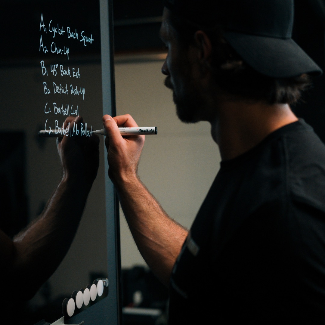 Peter writing a training block on a whiteboard